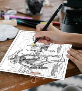 A person’s hand holding a coloring pen, carefully coloring a detailed western-themed coloring page. The page depicts a cowboy on horseback chasing a bull, capturing an action-packed rodeo scene.