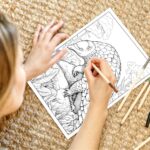 A young girl holding several colored pencils, coloring a detailed page of an African pangolin in its natural habitat, surrounded by trees and grass.