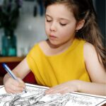 An 8-year-old girl coloring a detailed coloring page that depicts a western scene with a cowboy on horseback chasing a bull. The girl is focused on her artwork, adding color to the intricate design of the cowboy and bull.